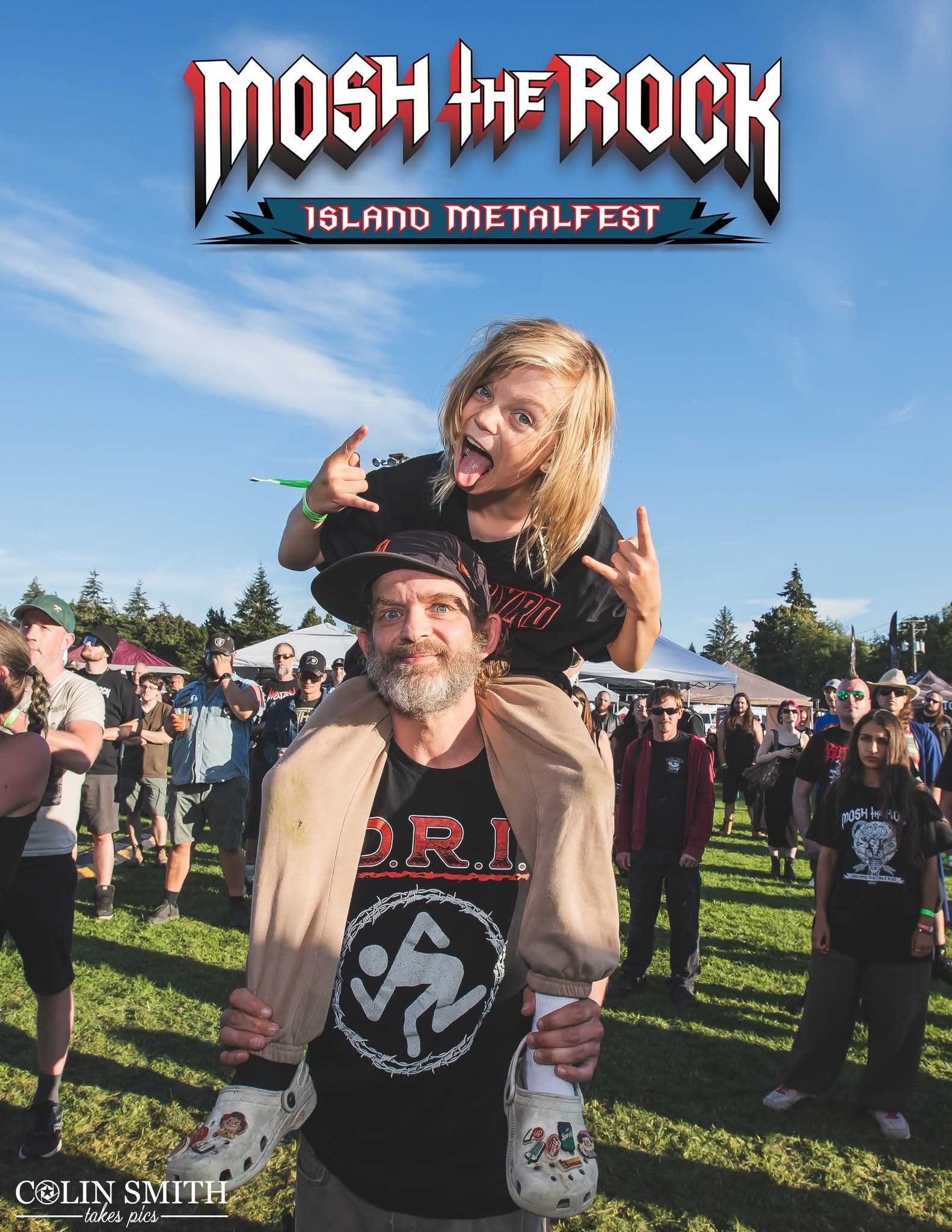 Kid on dad shoulders throwing the horns at Mosh the Rock