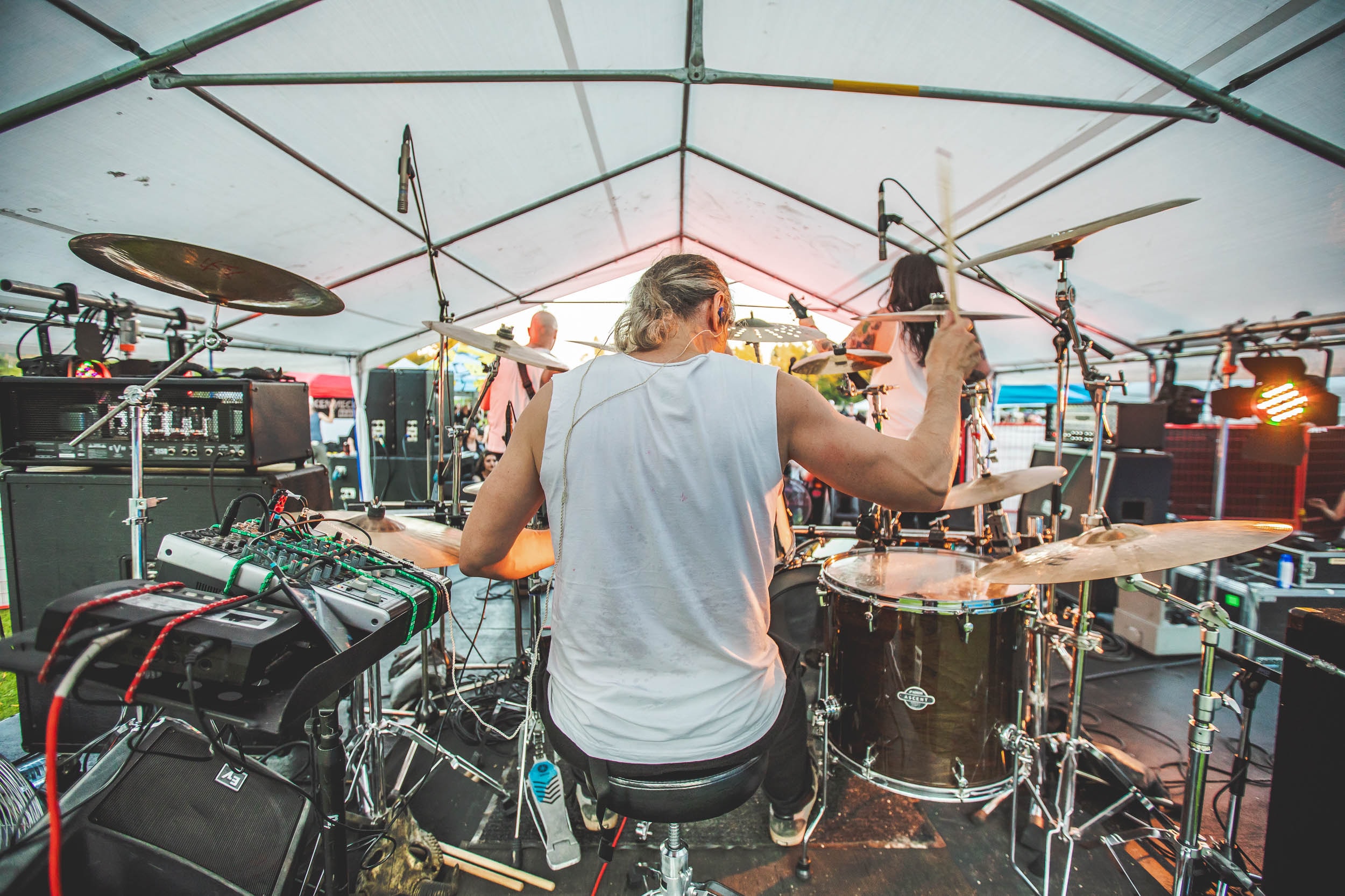 Drummer performing under the tent stage at Mosh the Rock Island Metalfest