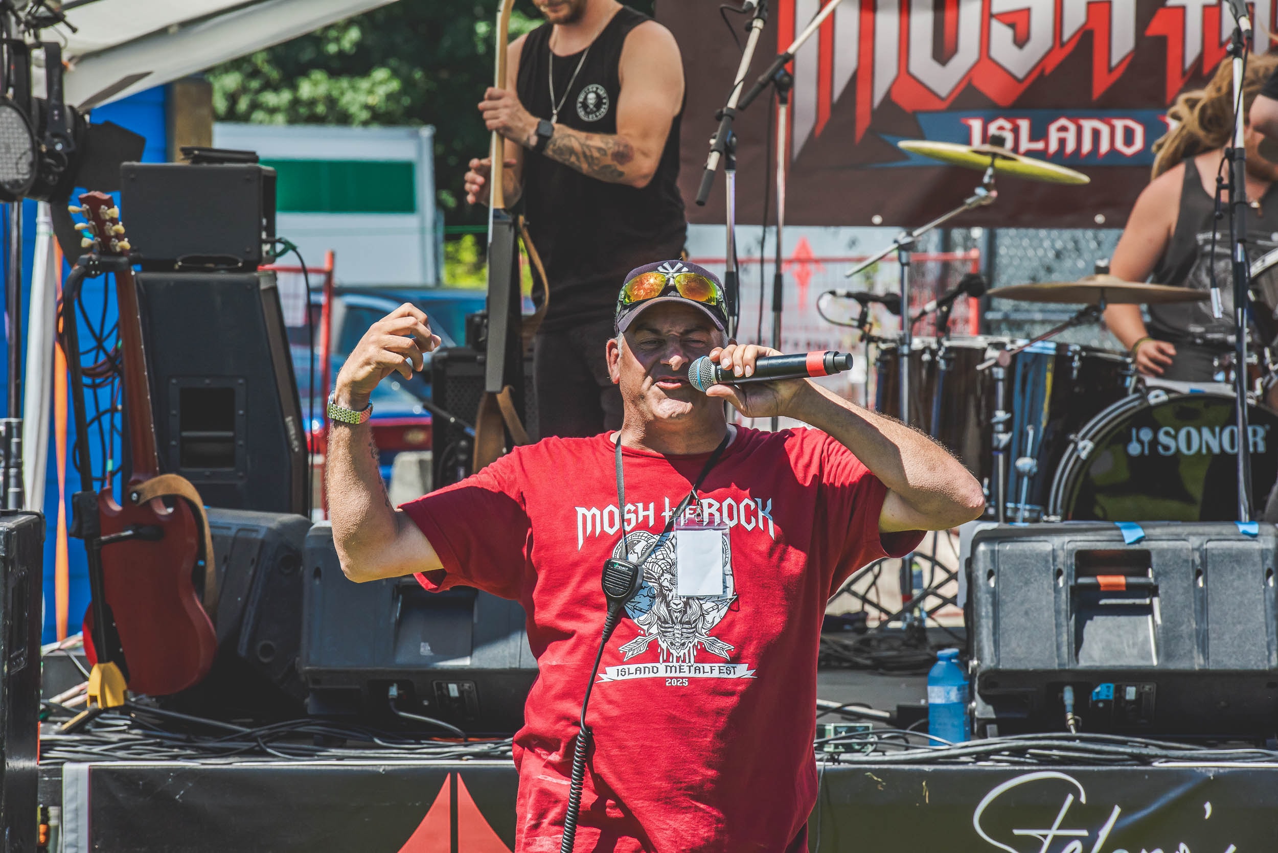 MC in a Mosh the Rock red shirt hyping the crowd on stage